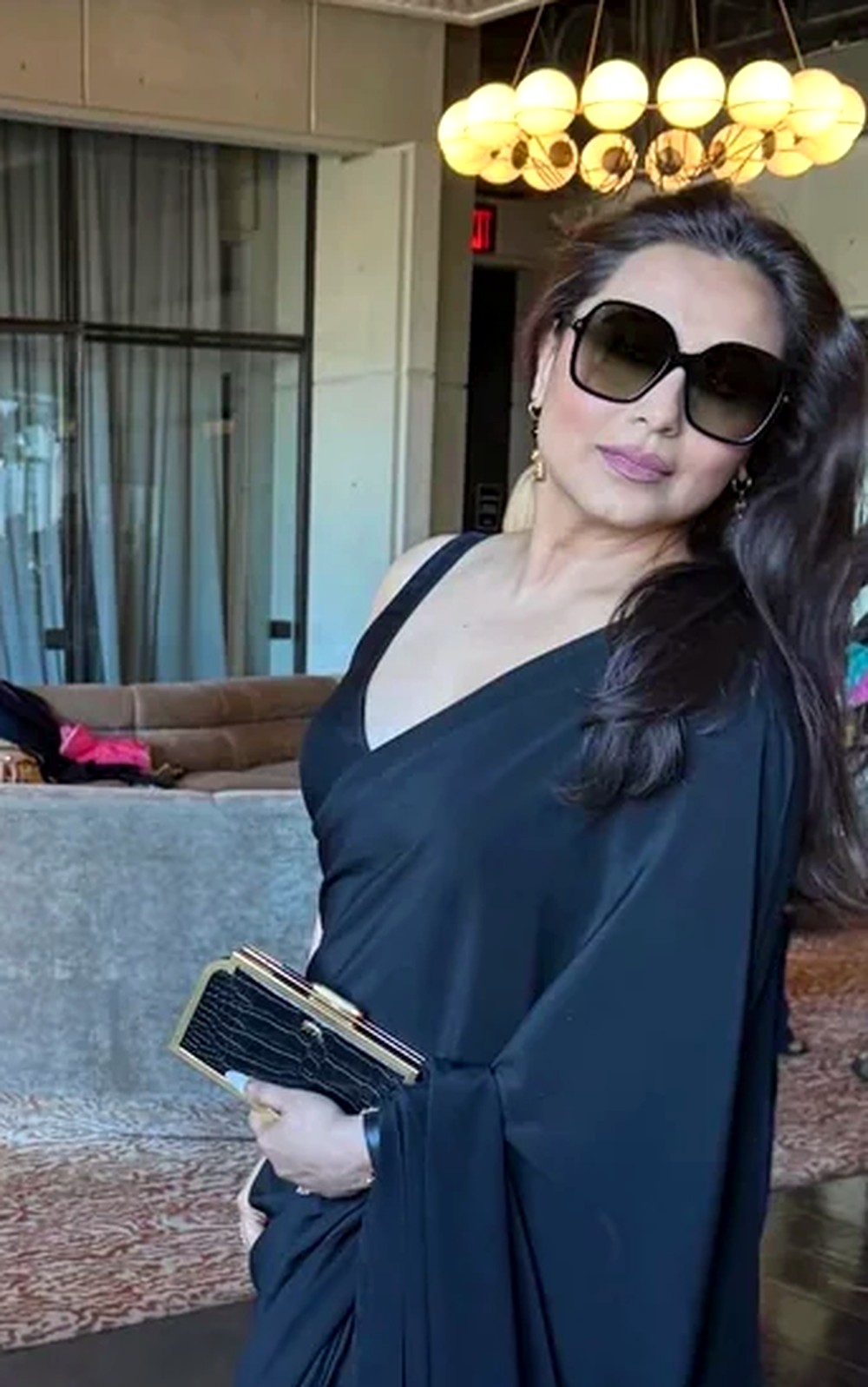 Rani Mukerji in a plain black silk saree with a sleeveless V-neck blouse, oversized sunglasses and gold jewellery, attending Sabyasachi's New York Fashion Week show