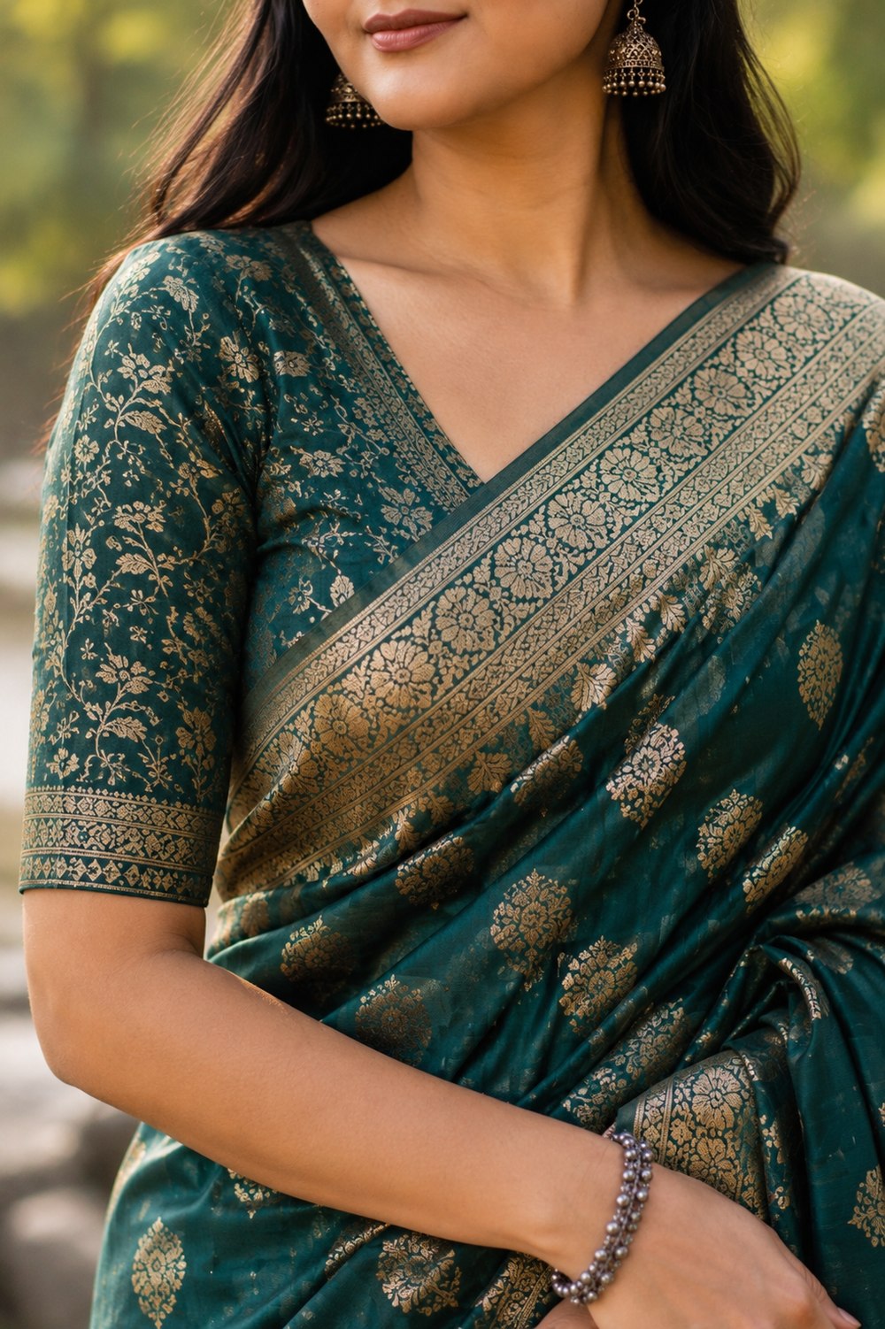 Close-up of a woman in a teal Banarasi silk saree with a gold zari border